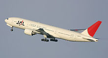 Aircraft takeoff. Side view of twin-engine jet in flight with flaps and landing gear extended, with upswept wings.