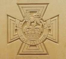 The cross patt&eacute;e bearing the crown of Saint Edward surmounted by a lion with the inscription FOR VALOUR etched into stone.