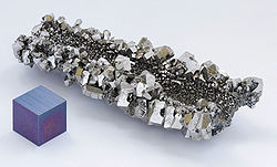 A lump of gray shining crystals with hexagonal facetting