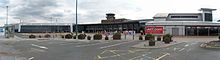 The frontage, consisting mainly three rows of glass panes, of a long building. Above the glass is a concrete section containing the words