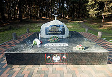 A large rock set on a pedestal of polished stone. On the pedestal, the words