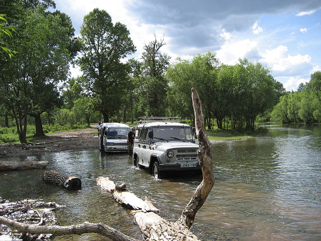 File:UAZ-469 towing a bus through a river in Mongolia.jpg